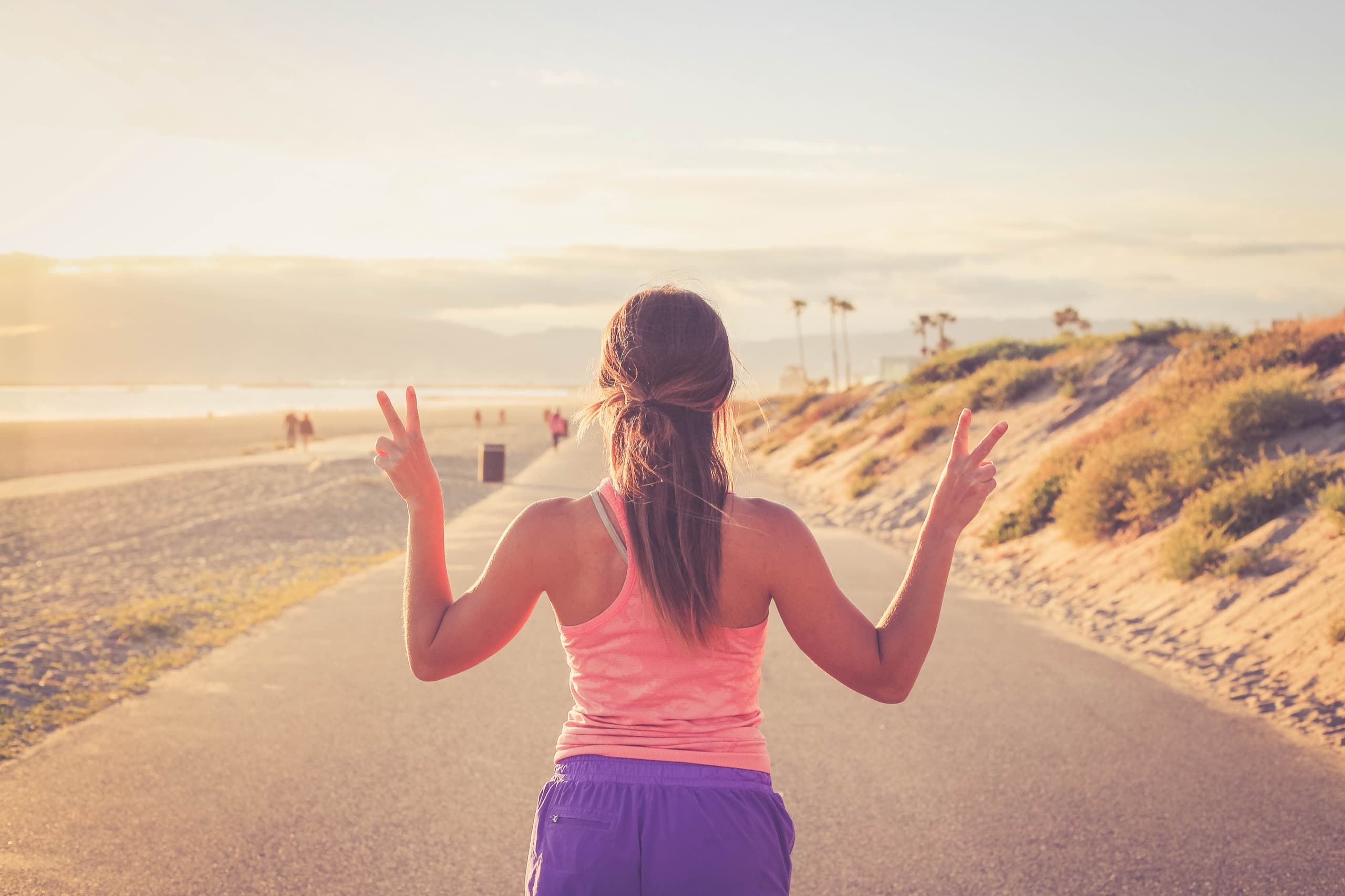 A woman running comfortably on a sunny seaside path